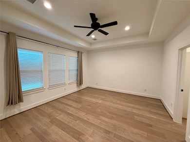 Spacious primary bedroom with stylized wood floori