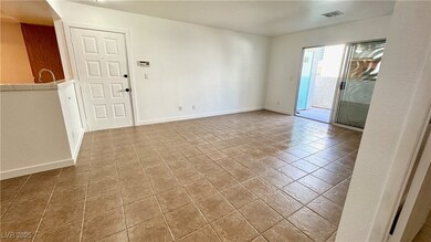 Tiled empty room featuring baseboards and visible