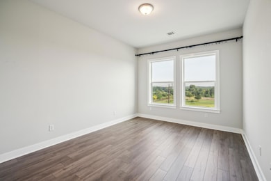 Spare room with baseboards and dark wood-style fl