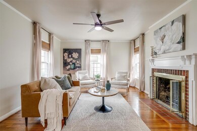 Living room with a brick fireplace, baseboards, or