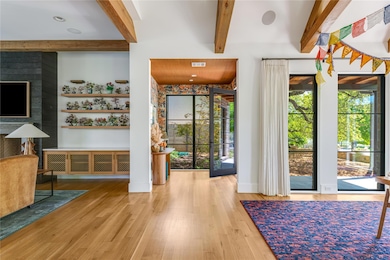 Entrance foyer with wood finished floors, beam ceiling, and visible vents