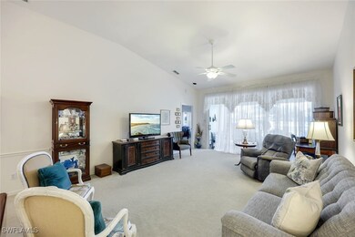 Carpeted living room with vaulted ceiling and ceil