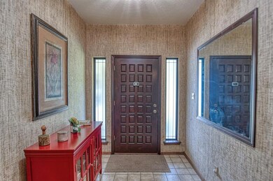 Foyer entrance featuring a textured ceiling and li