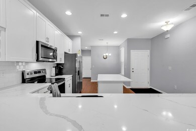 Kitchen with light stone countertops, white cabine