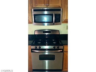 Kitchen - Stainless steel gas stove and microwave.