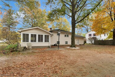 Back of property with a sunroom, a patio area, and a chimney