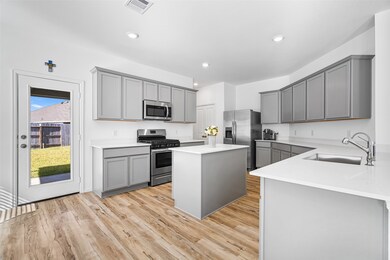 This stunning kitchen showcases a large island, sleek grey cabinetry, and a stainless steel appliances, blending contemporary elegance with warm, inviting style, perfect for cooking and entertaining in style.