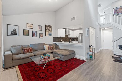 Living area with visible vents, high vaulted ceil