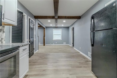 Kitchen with light stone countertops, black applia