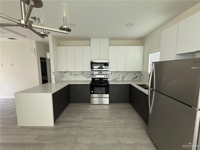 Kitchen with stainless steel appliances, a peninsula, modern cabinets, and backsplash
