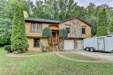 Split foyer home with a chimney, stone siding, dri