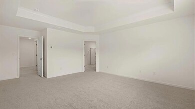 Unfurnished room featuring a raised ceiling and li