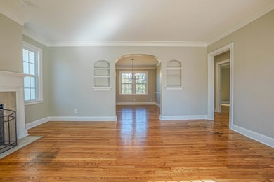 Living room featuring built in shelves, light wood
