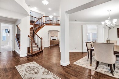 The foyer gives you a commanding view of the curved staircase leading to the second floor, plus glimpses of the kitchen, living room, family room and even the primary bedroom.