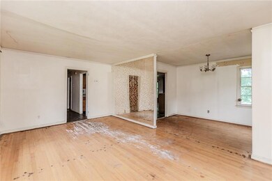 Unfurnished room with a chandelier, hardwood / wood-style flooring, crown molding, and baseboards