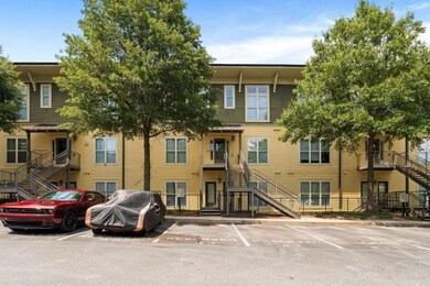 View of property featuring stairway and uncovered parking