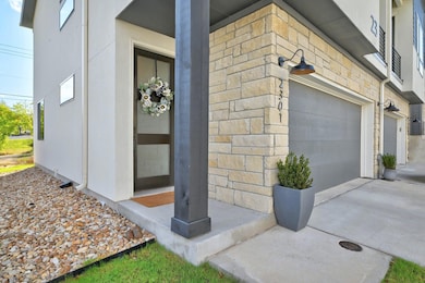 Doorway to property with stone siding, a garage, 