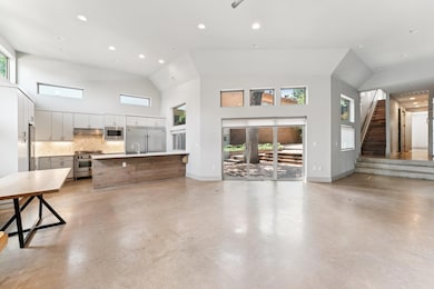 Unfurnished living room with high vaulted ceiling