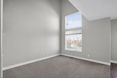 Empty room with carpet flooring and a towering ceiling