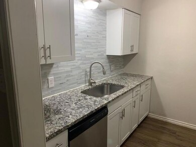 Kitchen featuring white cabinetry, baseboards, sta