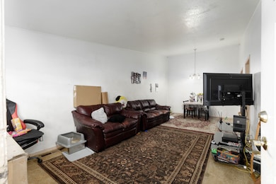 Living room featuring light carpet and a chandelier