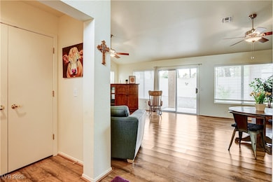 Living room with a ceiling fan, wood finished floo