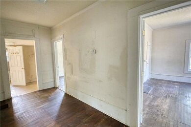 Empty room with hardwood / wood-style floors and o