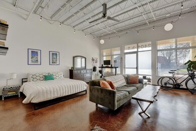 Bedroom with a towering ceiling and concrete floo