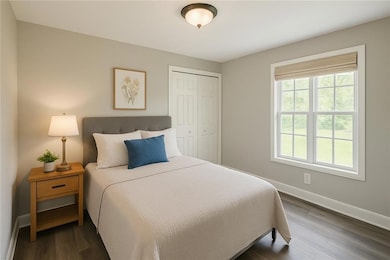 Bedroom with dark wood-type flooring and a closet