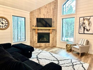 Living room with light wood-type flooring, vaulted
