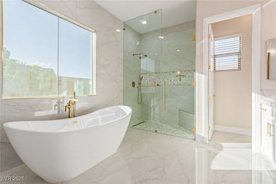 Bathroom with a freestanding bath, a marble finish shower, light marble finish flooring, stone wall, and recessed lighting