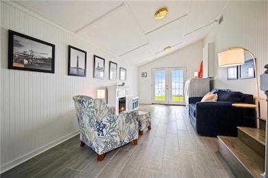 Living room with wood finished floors, vaulted cei