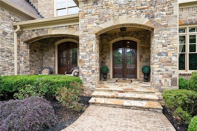 View of exterior entry with french doors and stone siding