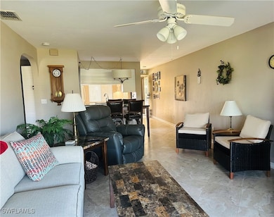 Living area featuring ceiling fan, arched walkways