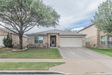 Single story home featuring roof with shingles, a front yard, driveway, and brick siding