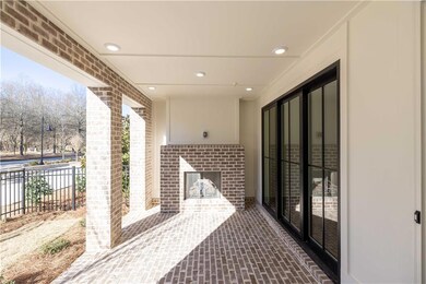 The covered patio features a beautiful brick floor and cozy fireplace.