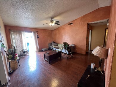 Living room with visible vents, vaulted ceiling, a