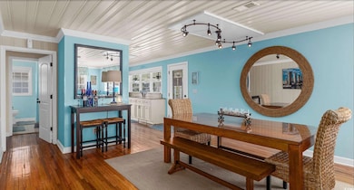 Dining room featuring ornamental molding and dark wood-style floors
