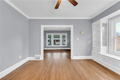 Spare room featuring light hardwood / wood-style floors, ceiling fan, and ornamental molding