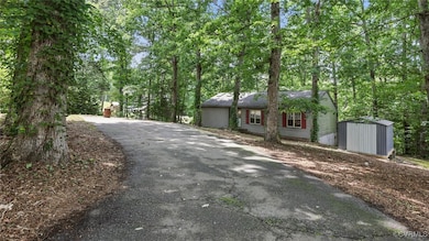 Ranch-style house with a shed and asphalt driveway