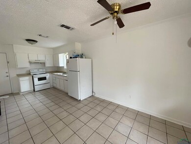 Kitchen with white appliances, ceiling fan, sink, 