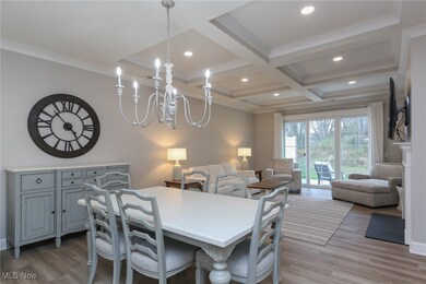 Dining area featuring light wood finished floors, beamed ceiling, coffered ceiling, recessed lighting, and crown molding
