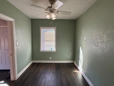 Empty room featuring ceiling fan and dark wood-typ