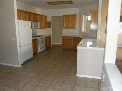 Kitchen with tile counters light wood cabinets and