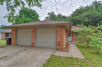 View of front of property featuring driveway, brick siding, an attached garage, and a shingled roof