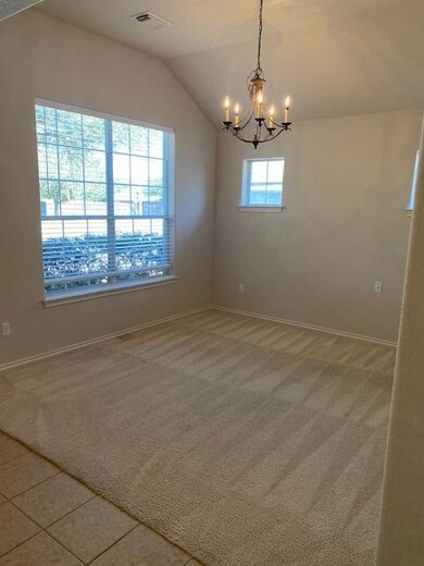 Spare room with a chandelier, light carpet, and v