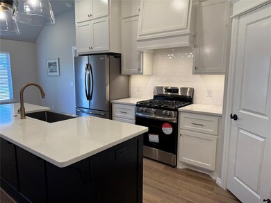 Kitchen with appliances with stainless steel finishes, decorative backsplash, dark cabinets, wood tiled floors, and light stone counters