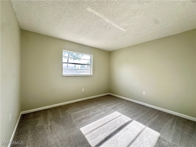 Carpeted spare room with a textured ceiling