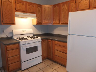 Fully applianced kitchen with tile floor.