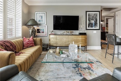 Living room with wood finished floors, crown moldi